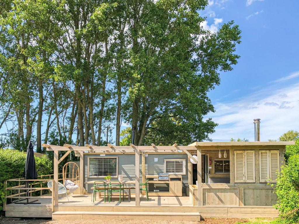 a tiny house with a porch and a patio at LODGES 7Huizen aan Zee in Scharendijke