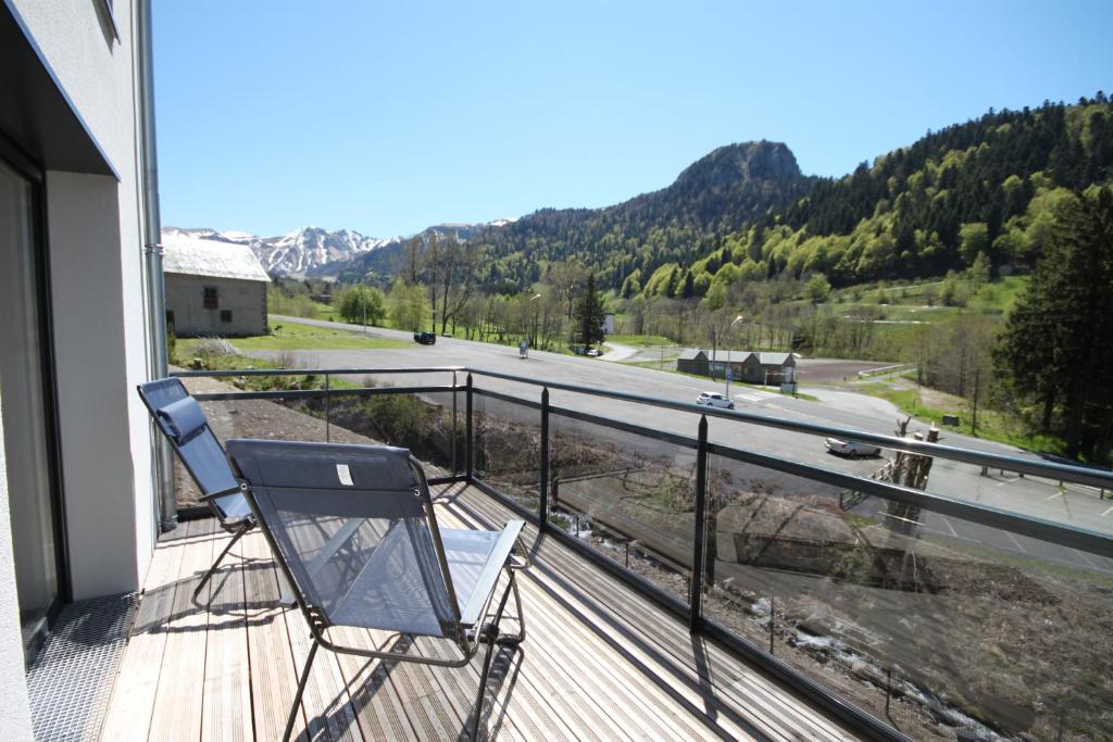 a balcony with a chair and a view of a road at C5 - Résidence La Montille in Le Mont-Dore