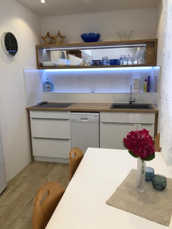 una cocina con una mesa con un jarrón de flores en Apartmani ROBERTA, en Bol