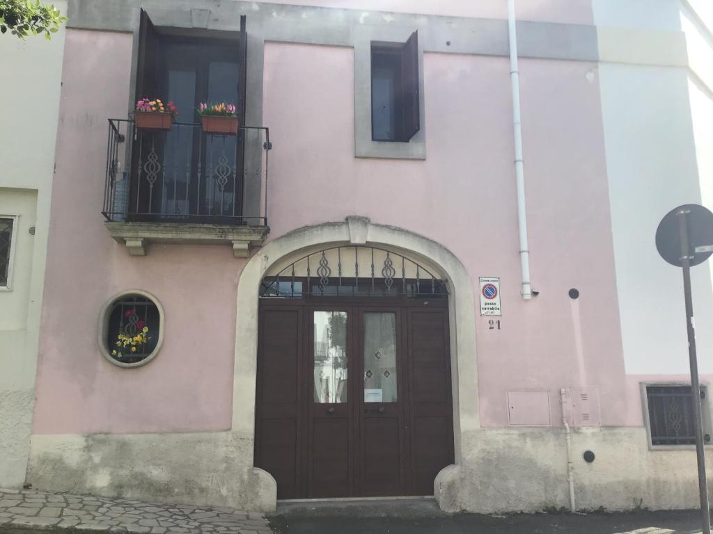 Edificio rosa con puerta y balcón en Dimora San Biagio, en Veglie