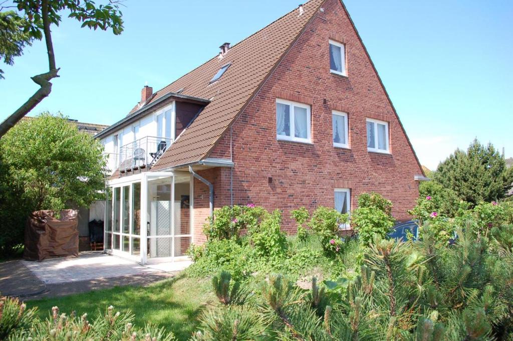 une grande maison en briques avec un toit dans l'établissement Hüs Lörki 1, à Westerland