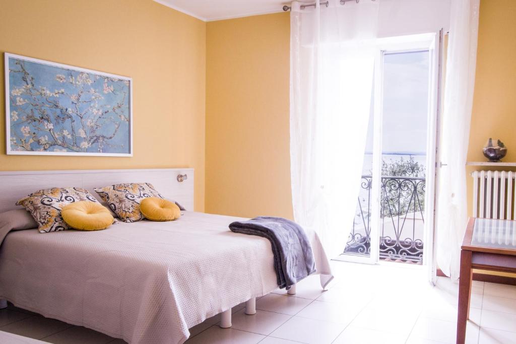 a bedroom with a bed and a large window at Appartamento DAISY in Bardolino