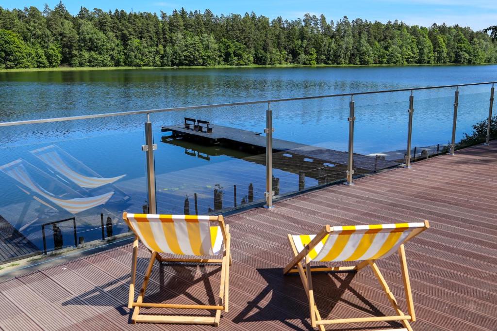 MielnoにあるKrokodylの湖畔の桟橋に座る椅子2脚