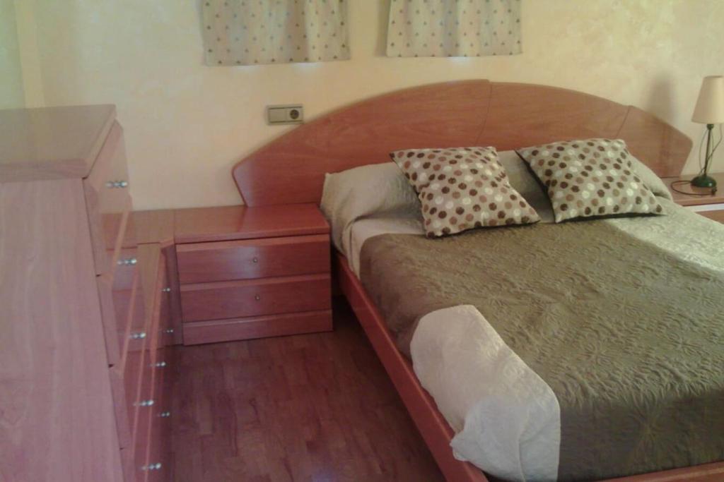 Cette chambre comprend un lit avec deux oreillers et une commode. dans l'établissement EL TRASTERO, à Santa Marta de Tormes
