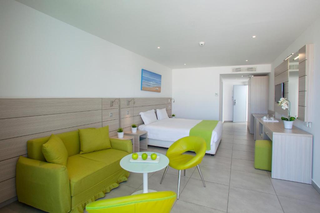 a hotel room with a couch and a bed at Limanaki Beach Hotel & Suites in Ayia Napa