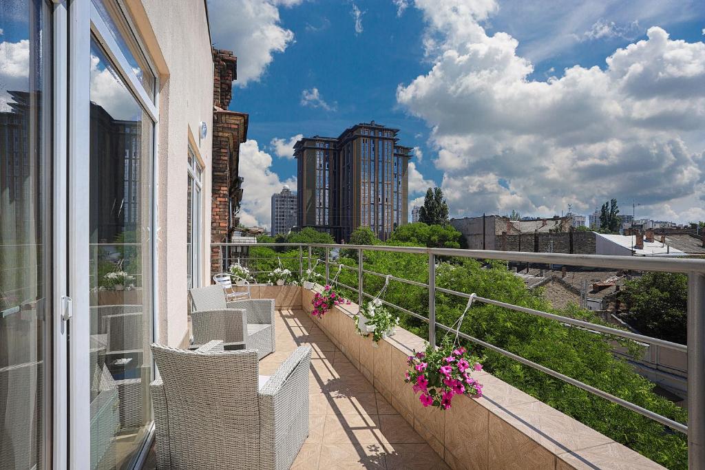 einen Balkon mit Stühlen und Blumen auf einem Gebäude in der Unterkunft Arnautskiy Hotel in Odessa