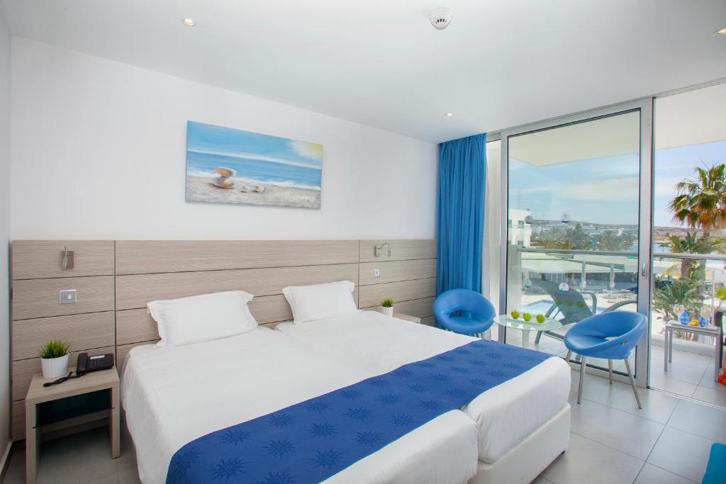 a hotel room with a bed and a balcony at Limanaki Beach Hotel & Suites in Ayia Napa