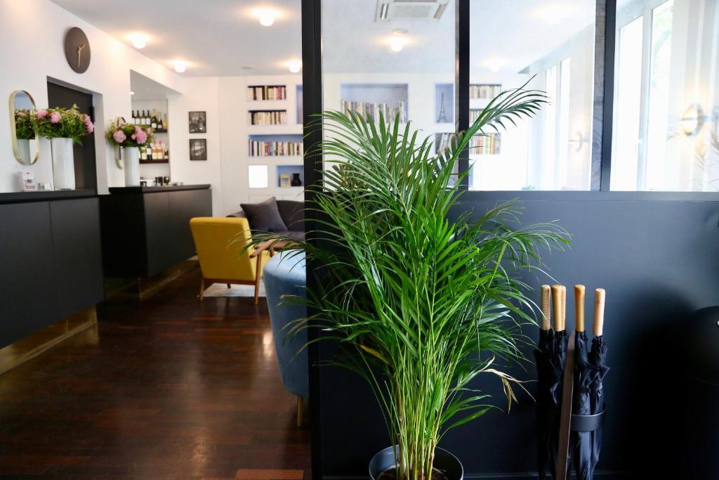 uma sala de estar com um vaso de plantas sobre uma mesa em Stella Etoile em Paris