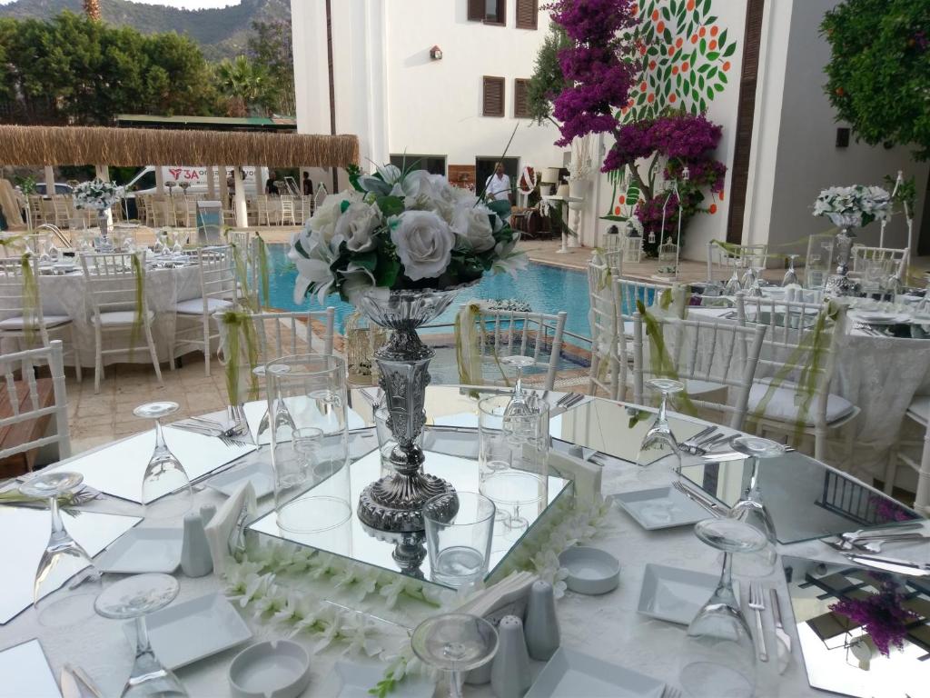 ece "vegan"hotel Bodrum في غولتوركبوكو: إعداد طاولة لحضور حفل زفاف مع إناء من الزهور