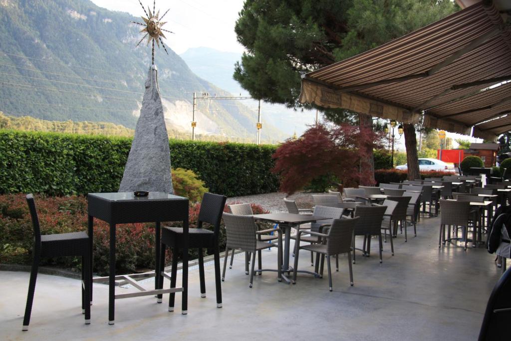 una fila de mesas y sillas en un restaurante en Hotel Du Soleil, en Saint-Léonard