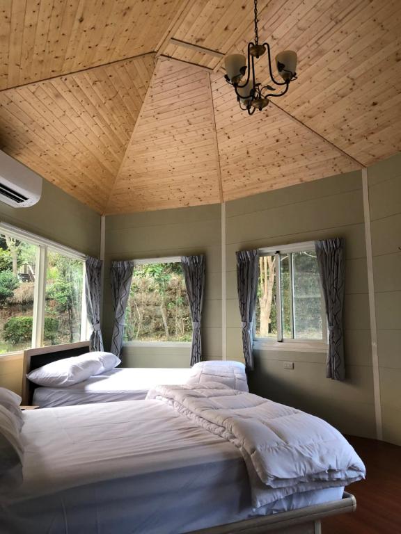 Postel nebo postele na pokoji v ubytování Yiyue Guanhe Homestay 倚月觀荷民宿