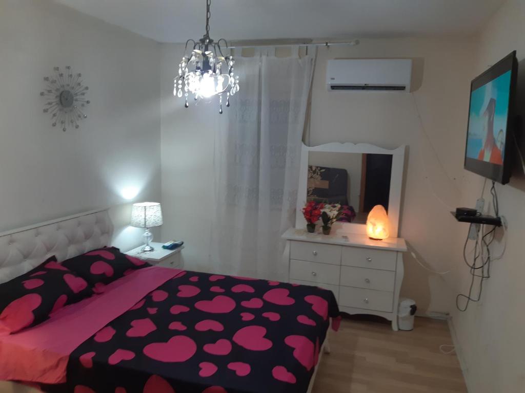 a bedroom with a bed and a dresser and a mirror at Dorit Vacation in Tiberias