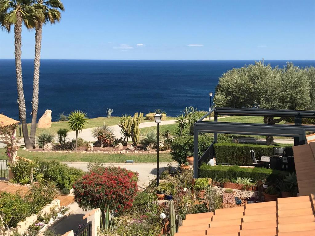 a view of a garden with the ocean in the background at LightHouse View I in Gran Alacant