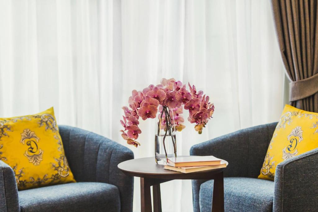 A small seating vignette with two upholstered armchairs, a table and orchids.