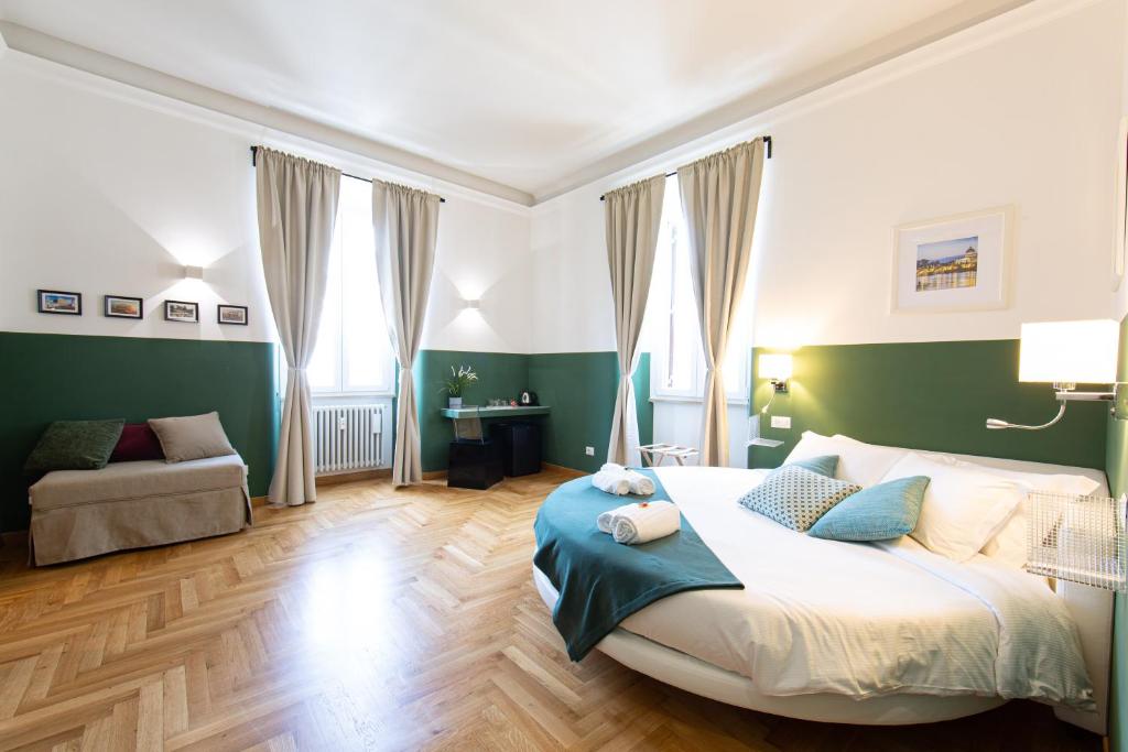 Un dormitorio con una cama grande y un sofá. en Lombardia40 Luxury Suites, en Roma