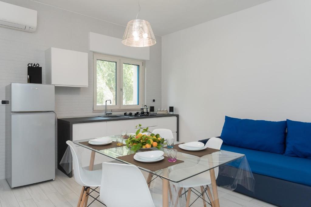 cocina y sala de estar con mesa y sofá azul en Scilla Marina, en Mattinata