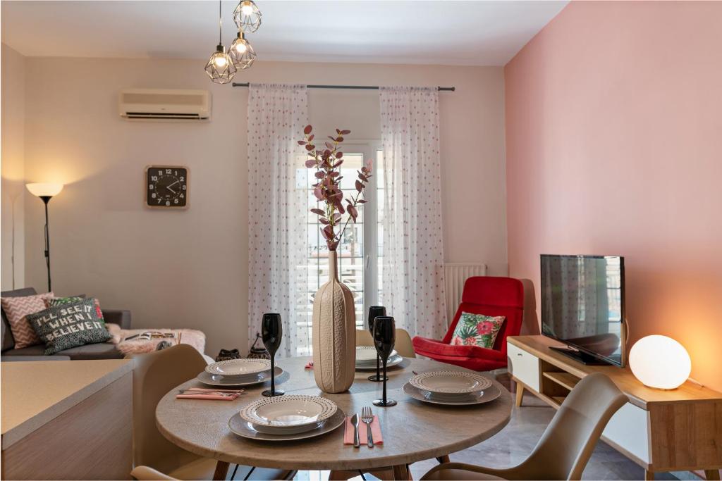 un soggiorno con tavolo e divano di Tres Jolie - Stylish Cityheart Apartment a Rethymno