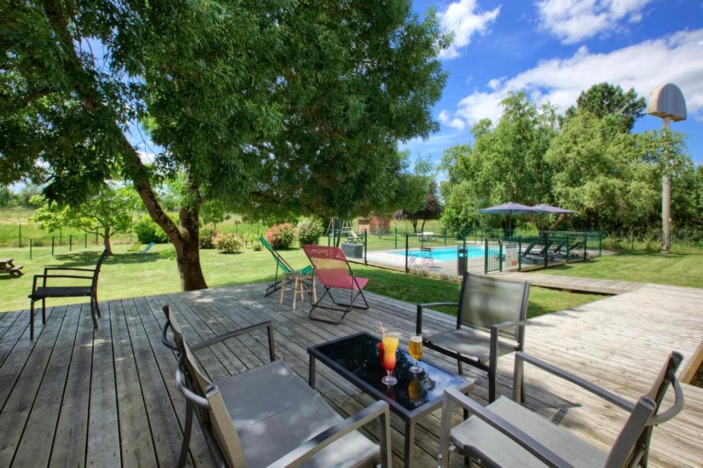 une terrasse avec des chaises, une table et une piscine dans l'établissement Kyriad Libourne Saint Emilion, à Arveyres