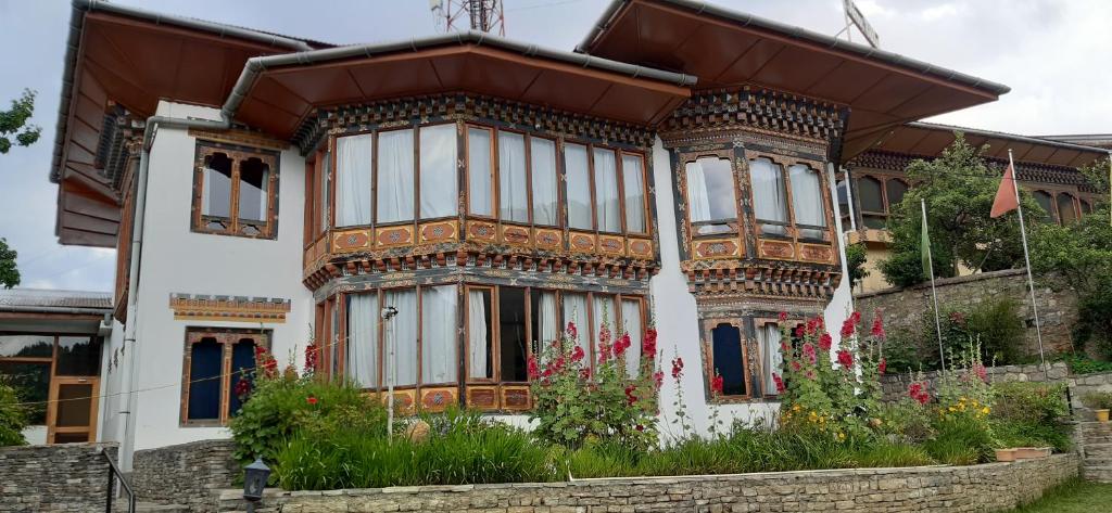 a house with a lot of windows and flowers at Kisa Villa in Thimphu