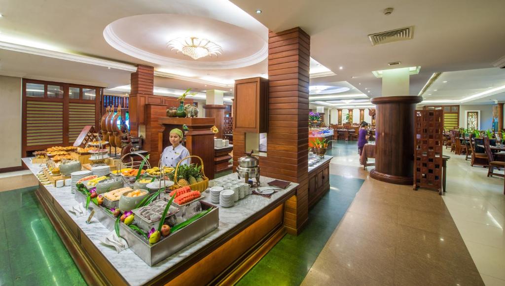 a woman standing behind a buffet in a hotel lobby at Borei Angkor Resort & Spa in Siem Reap