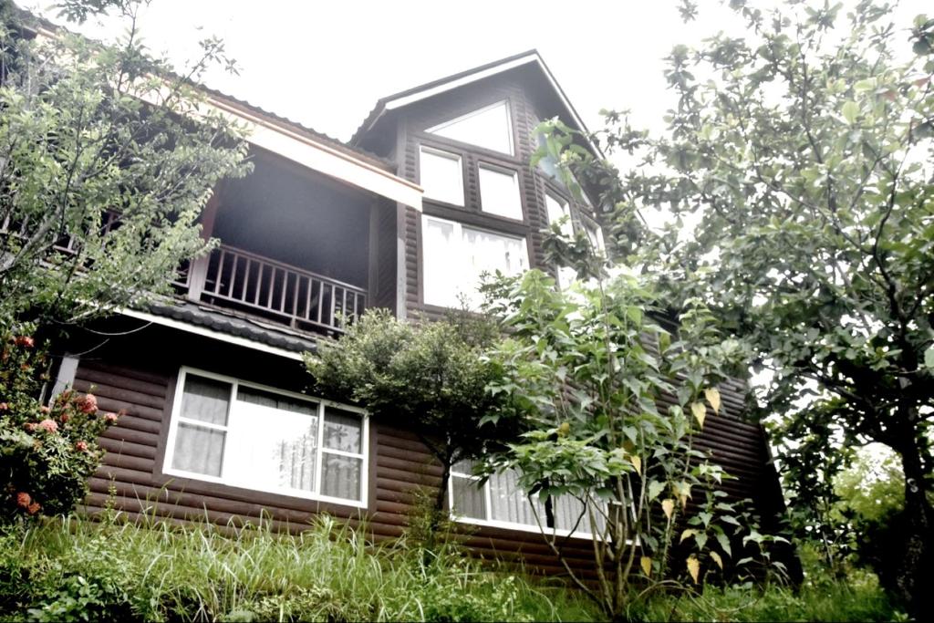 a house with windows and plants on the side of it at Yiyue Guanhe Homestay 倚月觀荷民宿 in Danei