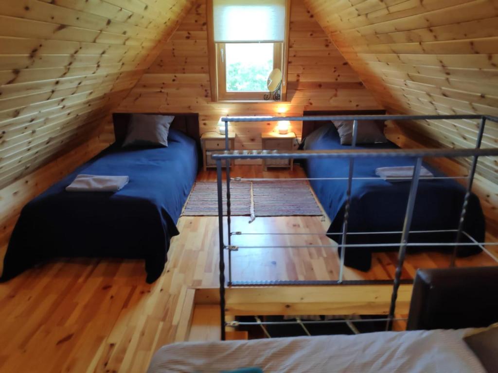 Un dormitorio con dos camas en una cabaña de madera. en Brīvdienu mājiņas Zemzari, en Jūrkalne