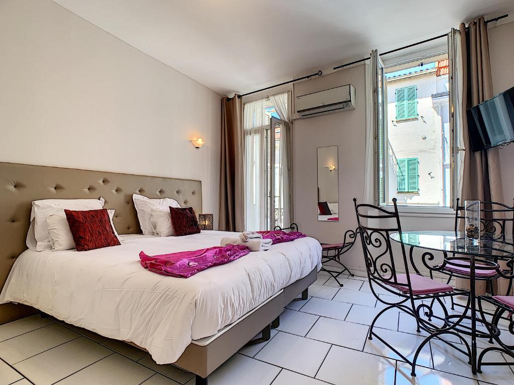 Schlafzimmer mit einem Bett, einem Tisch und Stühlen in der Unterkunft Residence Chryseis in Cannes