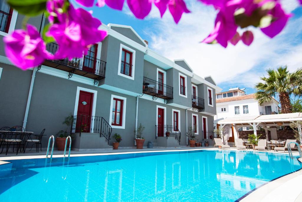 a villa with a swimming pool in front of a building at Kapya Cunda in Ayvalık