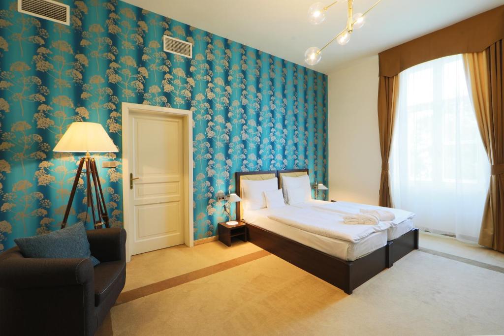 1 dormitorio con 1 cama y 1 silla en Ipoly Hotel Boutique Rooms & Suites, en Balatonfüred