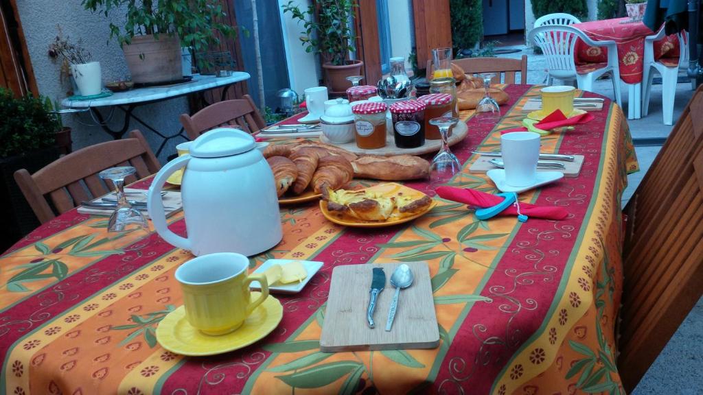 uma mesa com uma toalha de mesa com comida em L'Oustalet em Sisteron