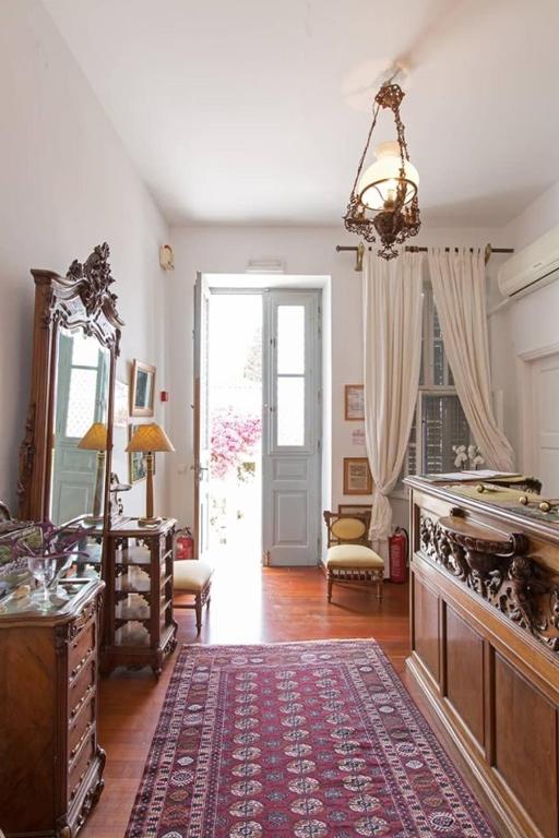 a living room with a table and a rug at Hotel Miranda in Hydra
