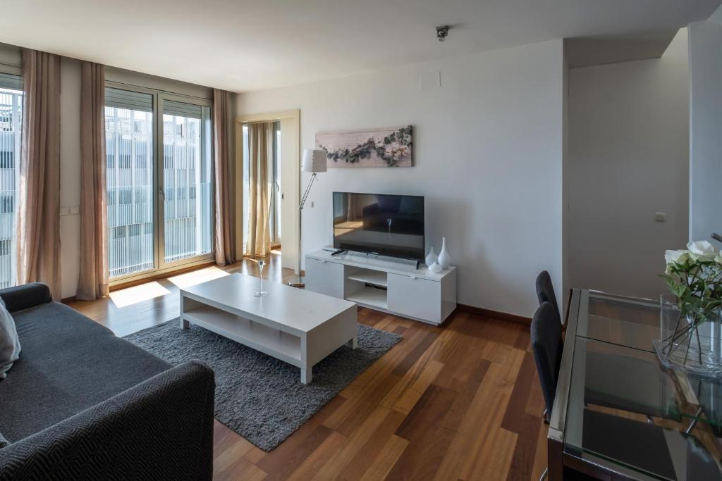 a living room with a couch and a tv at Rent Top Apartments Forum in Barcelona