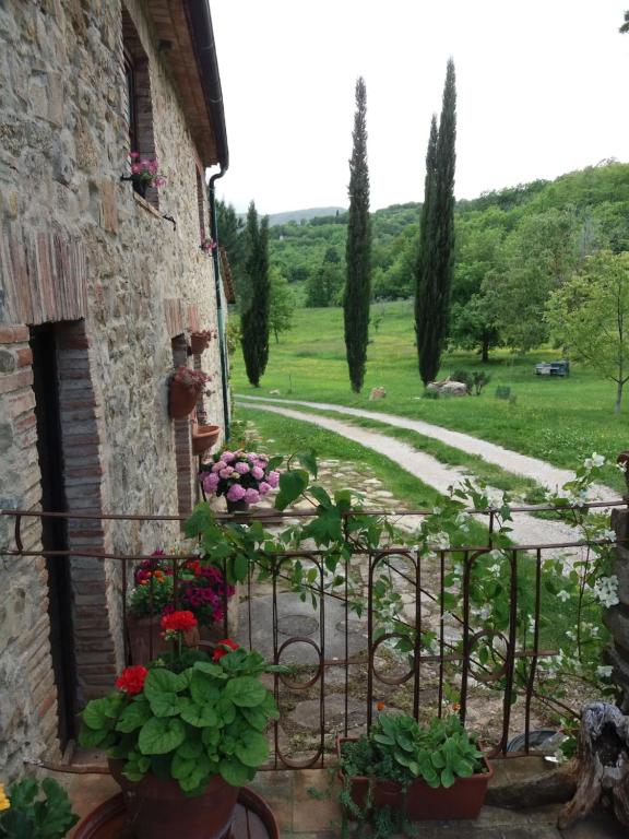 une maison en pierre avec des fleurs et un jardin dans l'établissement Podere Pian di Cava, à Castelnuovo di Val di Cecina