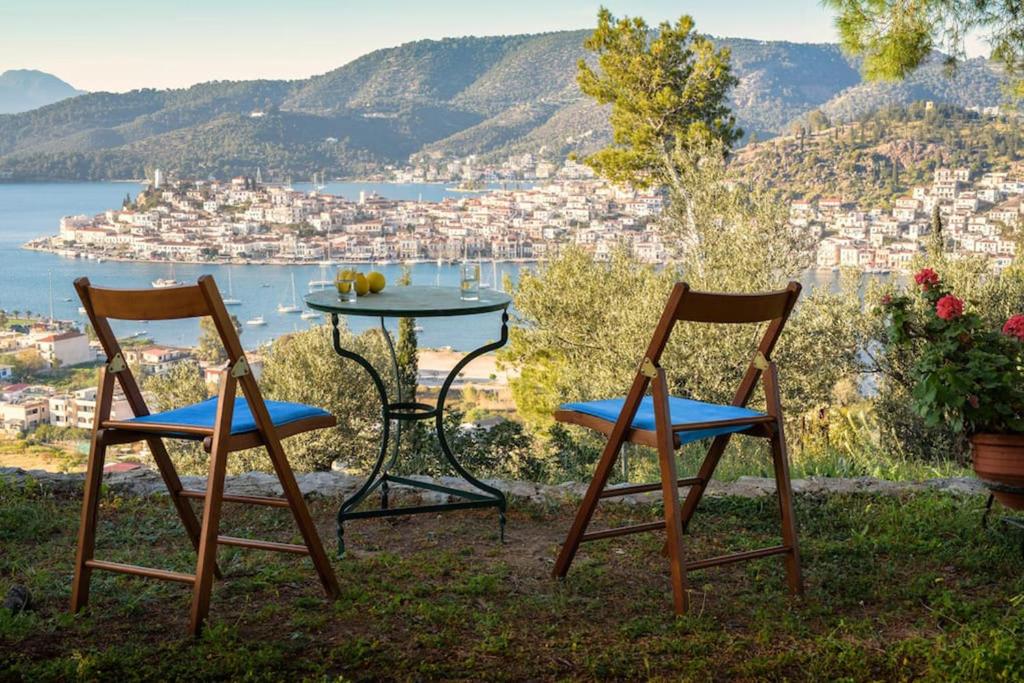 deux chaises et une table avec vue sur une ville dans l'établissement Estate with amazing views of Poros, à Poros