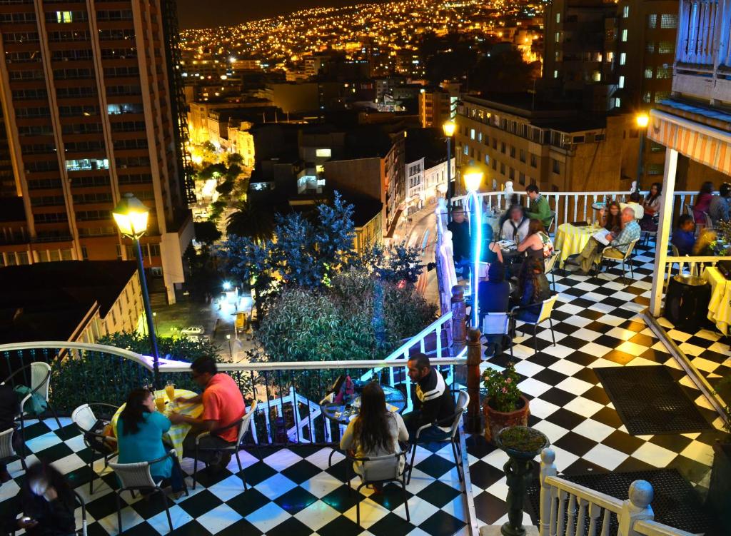 a group of people sitting on a balcony at night at Hotel Brighton in Valparaíso