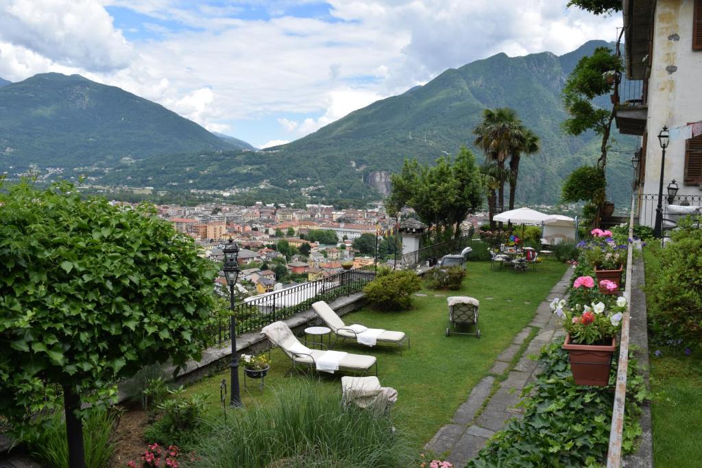 a garden with white furniture and a view of a city at B&B Villa Moro - Family House in Domodossola
