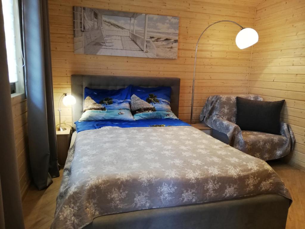 a bedroom with a large bed and a chair at Domek nad morzem in Będzino