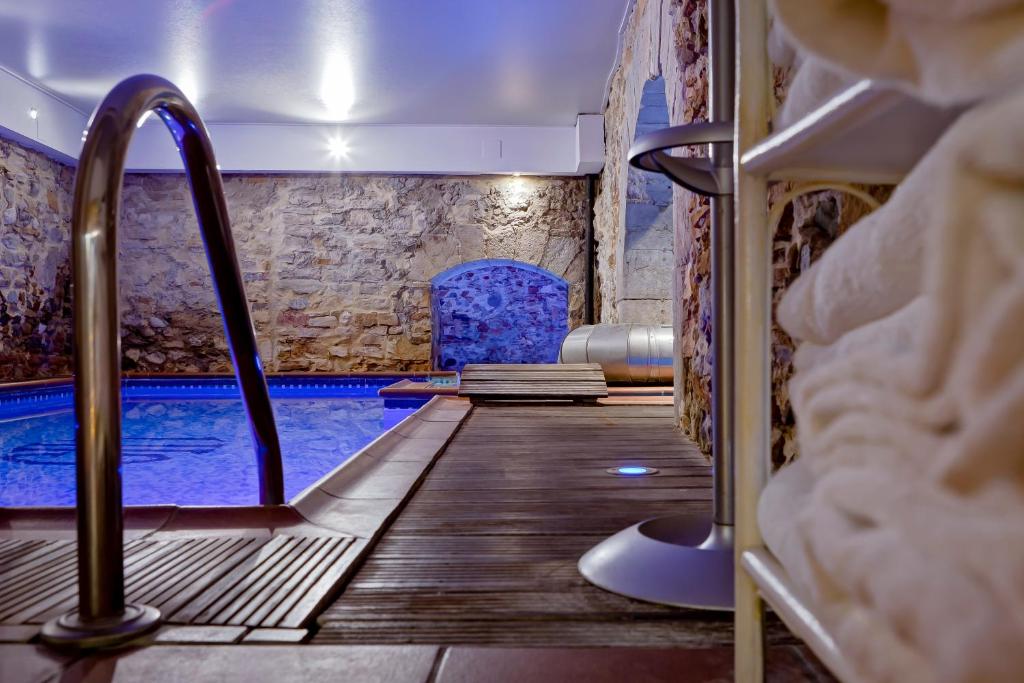 um quarto com uma piscina com piso em madeira e uma cadeira em Grand Hotel des Terreaux em Lyon