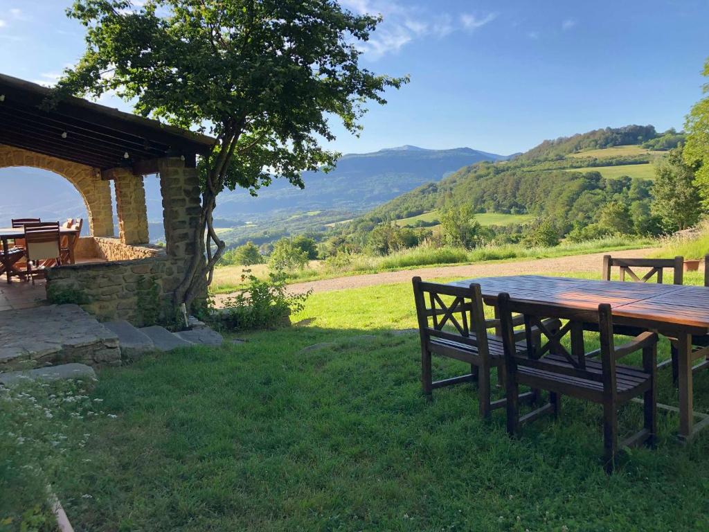 un tavolo e sedie in legno in un campo con un albero di Weekend en Provence a Comps