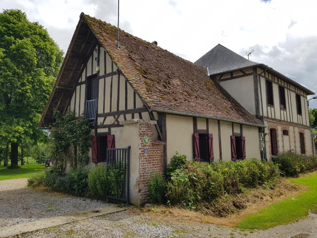 an old black and white house with red shutters at Gite à la ferme in La Ferté-Saint-Samson