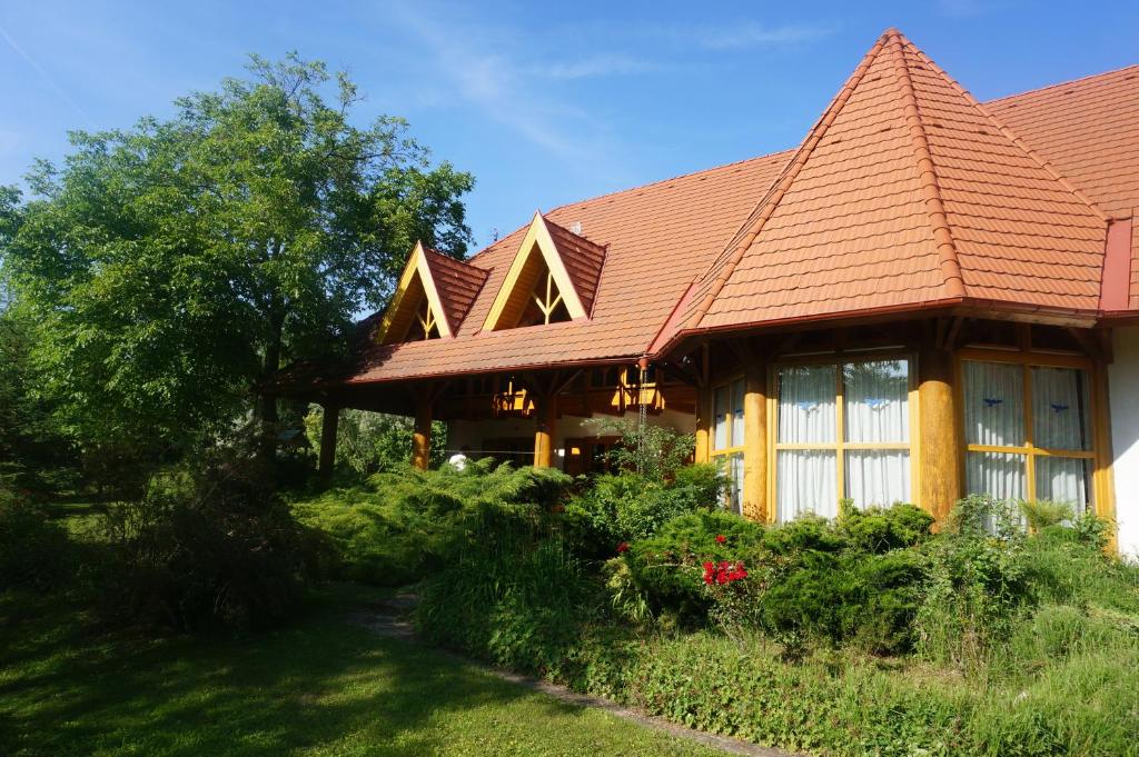 dom z czerwonym dachem i dziedzińcem w obiekcie Kiskúti Vendégház w mieście Monoszló