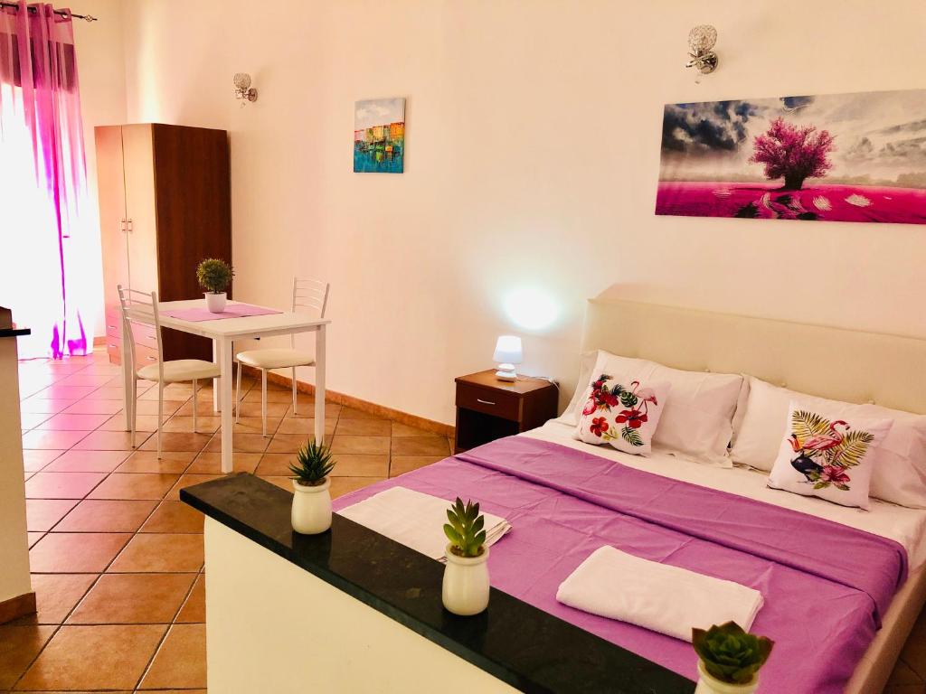 a small room with a bed and a table and a dining room at Carlottas'home in Catania