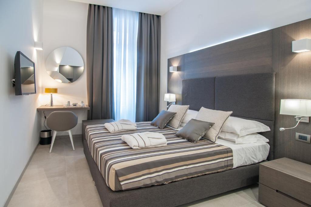 1 dormitorio con 1 cama grande y escritorio en Wellness Home Rome, en Roma