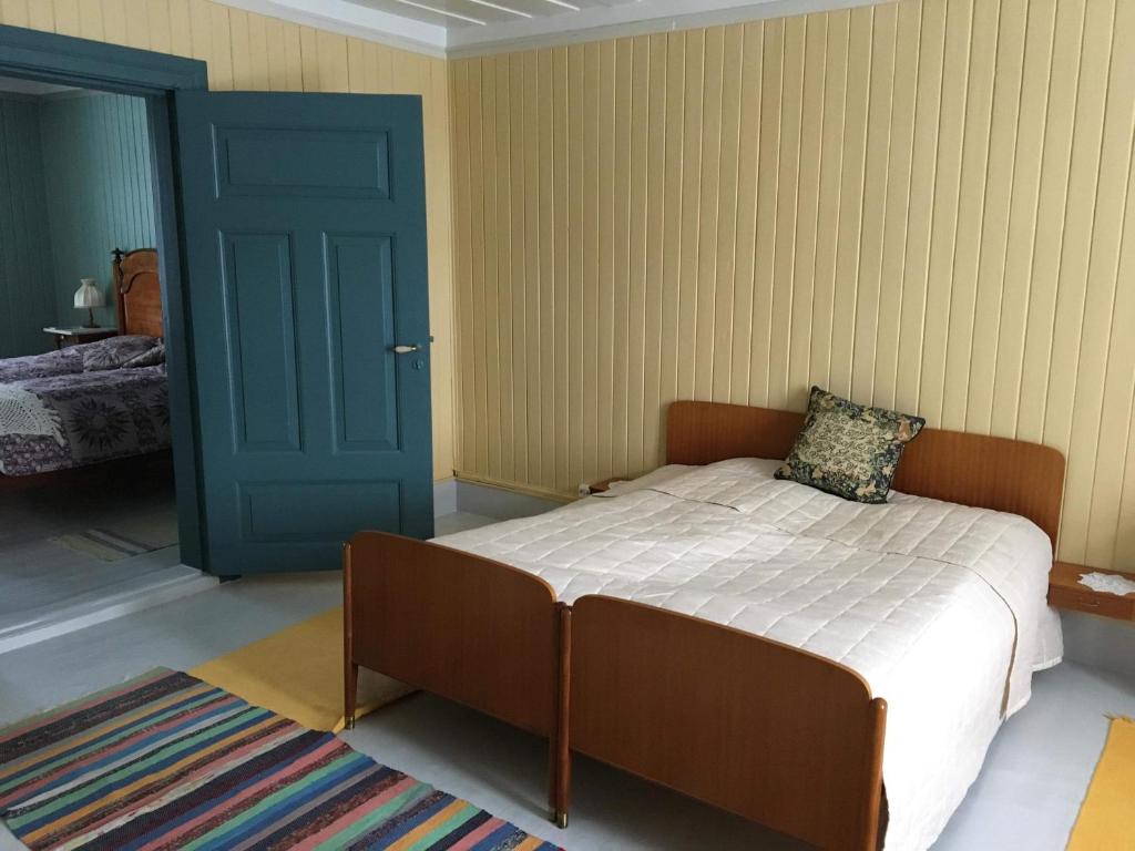 a bedroom with a bed and a blue door at Skjeggestad Gjestehus in Ringebu