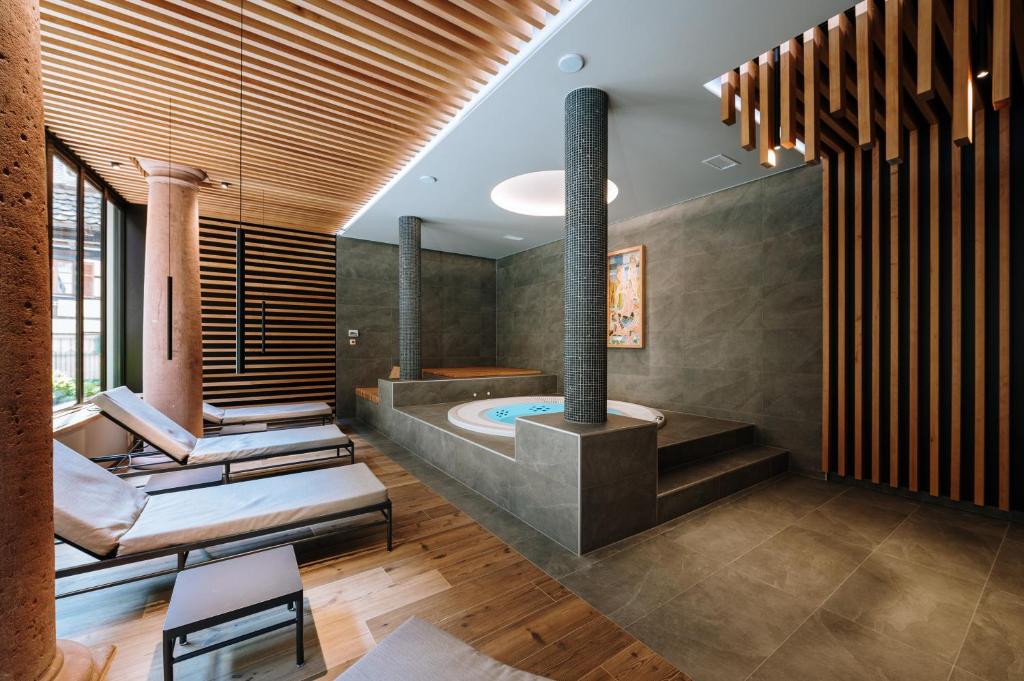 a bathroom with a plunge pool and a tub at Hôtel De La Tour in Ribeauvillé