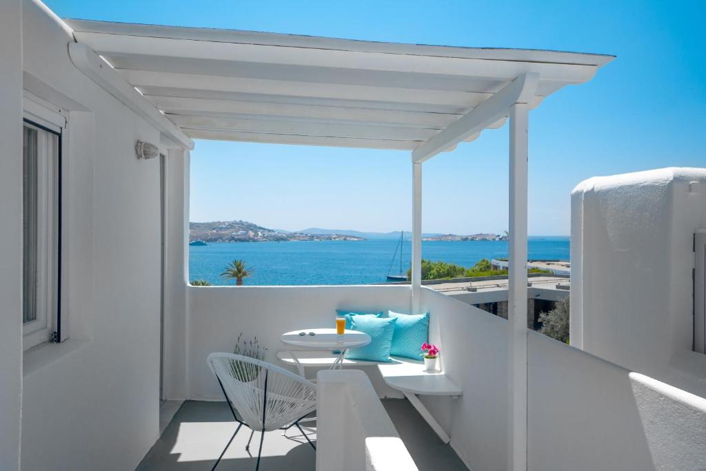 einen Balkon mit einem Tisch und Meerblick in der Unterkunft Central Suites Mykonos in Mykonos Stadt