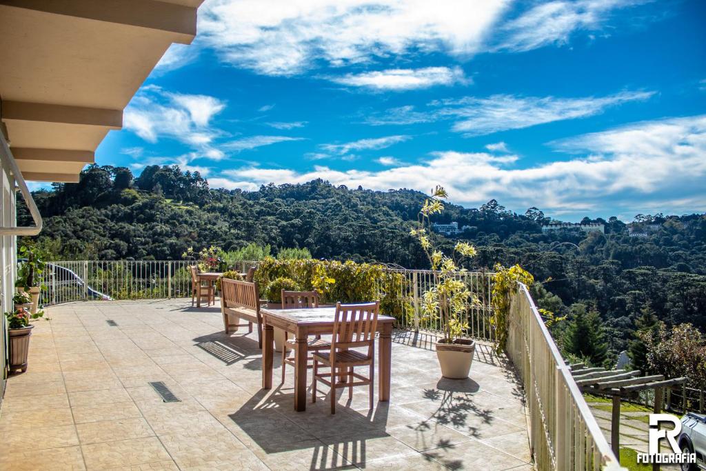 um pátio com uma mesa e cadeiras numa varanda em Pousada Bosque das Araucárias em Campos do Jordão