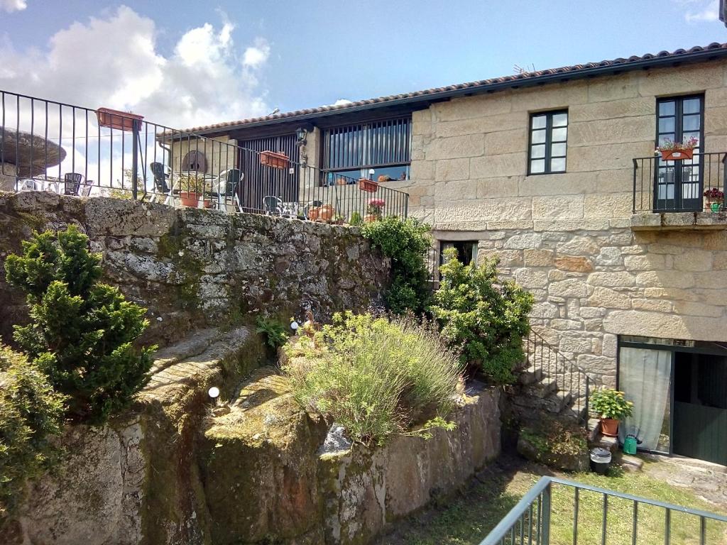 an old stone house with a stone wall at Caserio de Fontes in Nogueira de Ramuin