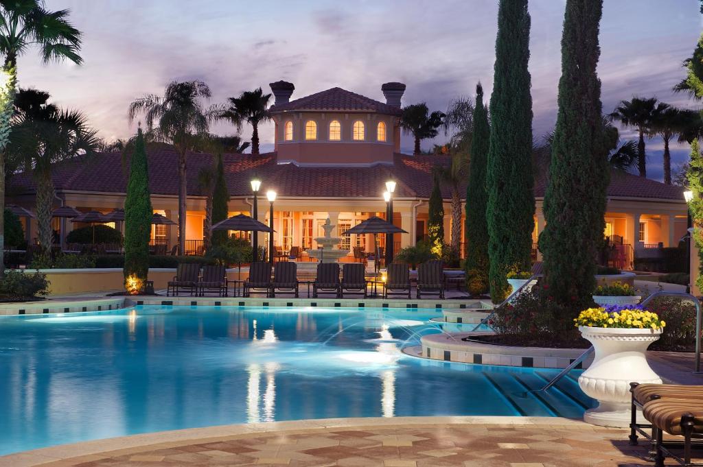 een groot huis met een zwembad in de nacht bij WorldQuest Orlando Resort in Orlando