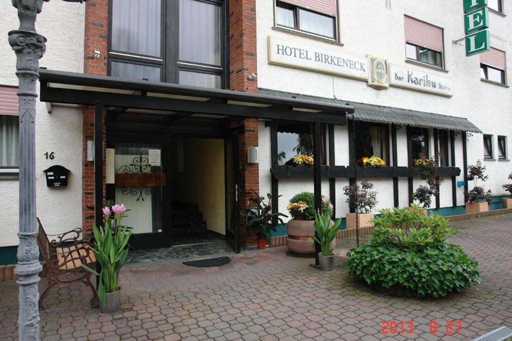 uma entrada do hotel com um banco em frente a um edifício em Birkeneck em Heusenstamm